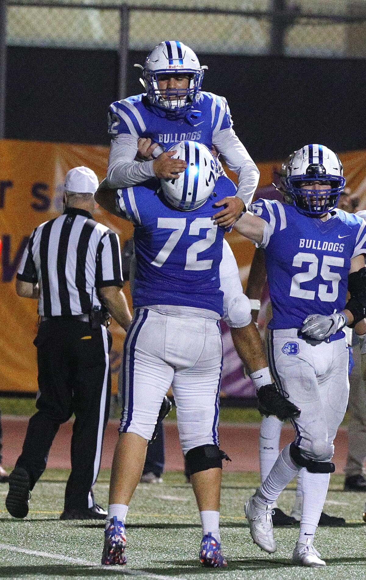 Burbank's Max Mendieta, who sacked the Muir quarterback, is hoisted into the air to celebrate by teammate Craig Rushton in a Pacific League football game at Burroughs High School on Monday, October 14, 2019.