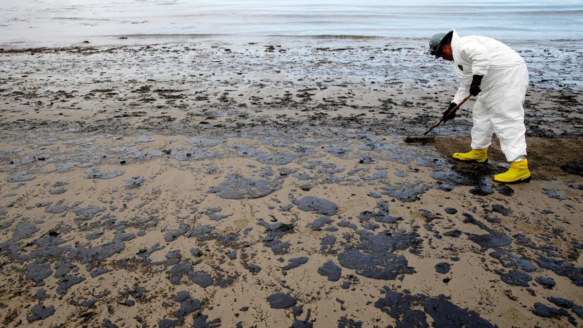 A worker removes oil from the sand at Refugio State Beach in the Santa Barbara Channel, north of Goleta, after a May 2015 oil spill.