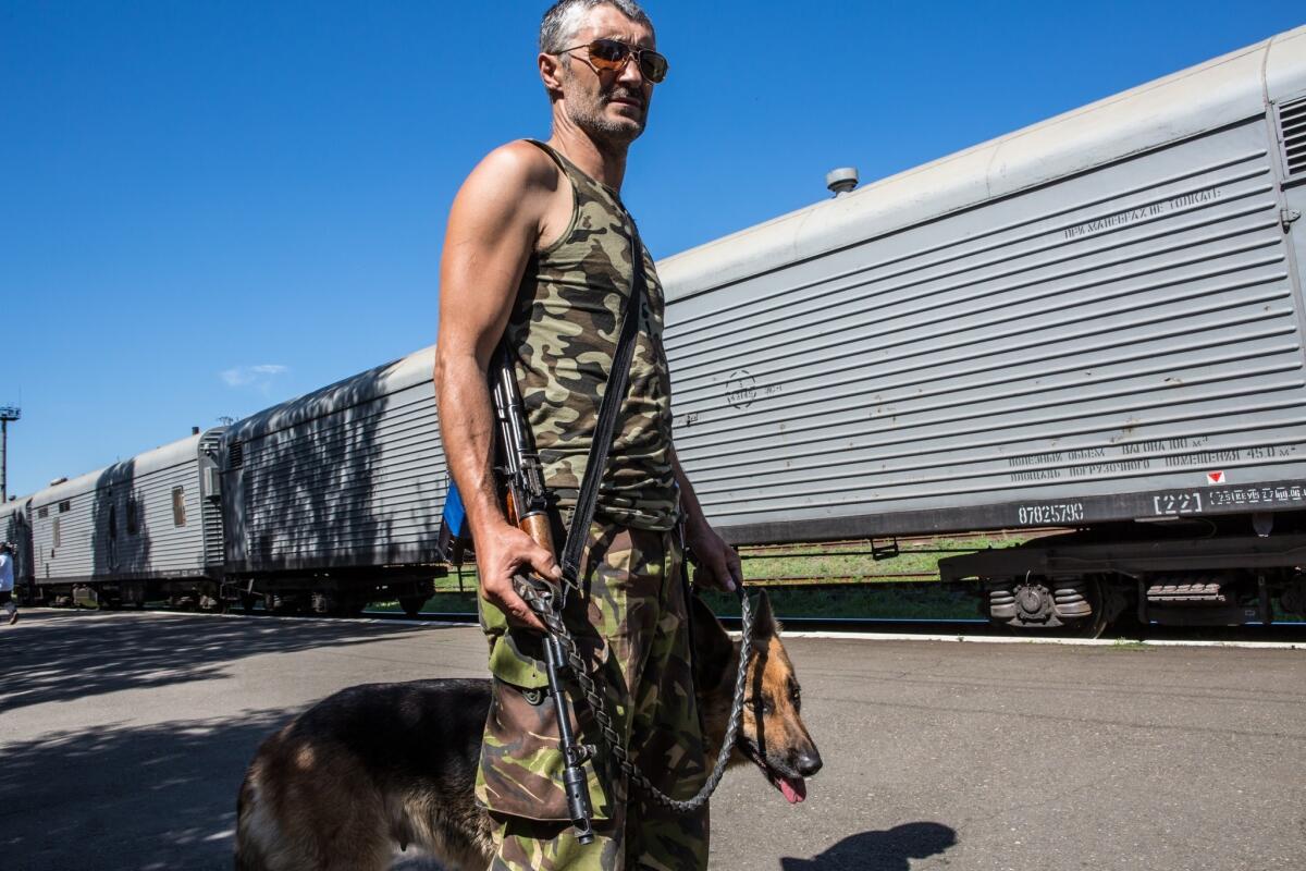 A pro-Russia separatist in Torez, Ukraine, guards train cars containing bodies from the downed Malaysian Airlines jet.