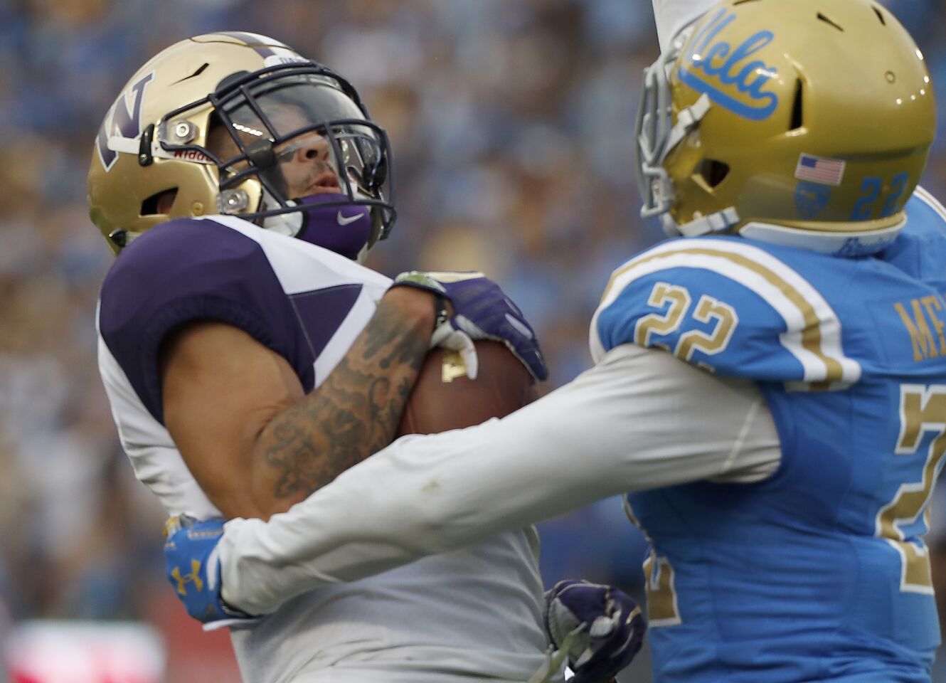 Washington wide receiver Aaron Fuller makes a touchdown catch in front of UCLA defensive back Nate Meadors in the first quarter on Saturday at the Rose Bowl.