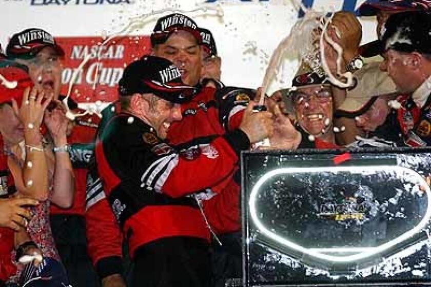 Greg Biffle sprays champagne as he celebrates his Pepsi 400 victory with his crew in Victory Lane Saturday night.