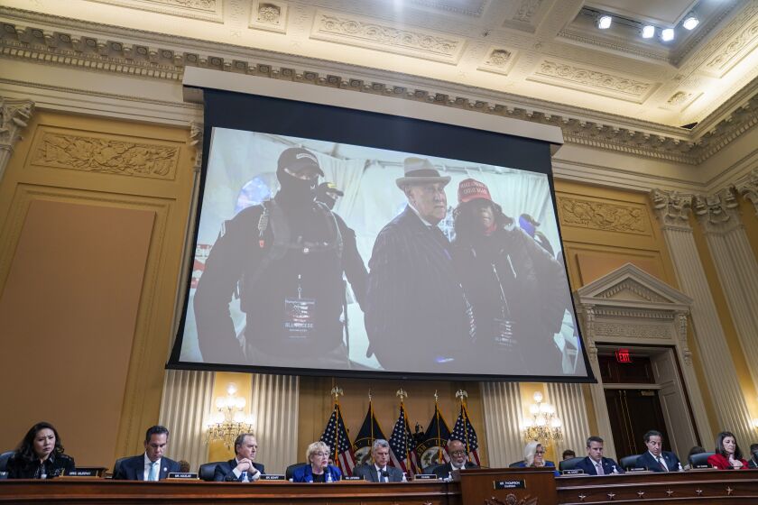 WASHINGTON, DC - OCTOBER 13: A photo of Roger Stone, former adviser to Donald Trump's presidential campaign, with members of the Oath Keepers is projected on a screen during a hearing of the House Select Committee to Investigate the January 6th Attack on the United States Capitol in the Cannon House Office Building on Thursday, Oct. 13, 2022 in Washington, DC. The bipartisan Select Committee to Investigate the January 6th Attack On the United States Capitol has spent nearly a year conducting more than 1,000 interviews, reviewed more than 140,000 documents day of the attack. (Kent Nishimura / Los Angeles Times)