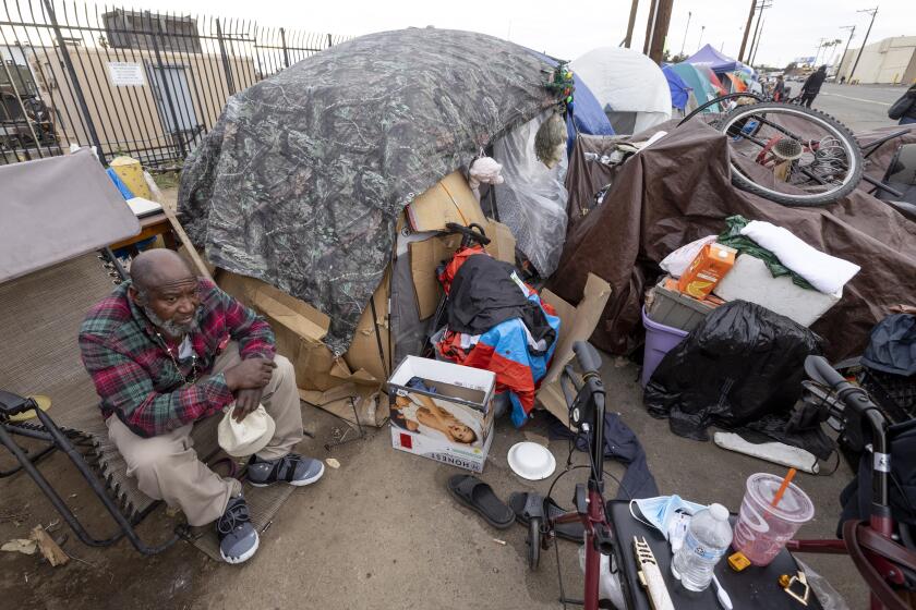 SAN DIEGO, CA - JANUARY 31, 2022: A 61-year-old homeless man, who says his name is Martin C and that he's a disabled Marine veteran, sits next to his tent at a homeless encampment on Sports Arena Boulevard in San Diego on Monday, January 31, 2022. (Hayne Palmour IV / For The San Diego Union-Tribune)