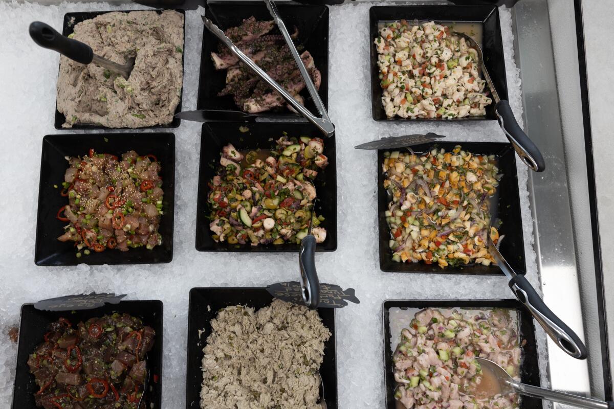 Fish-based salads are for sale in a case at TunaVille market.