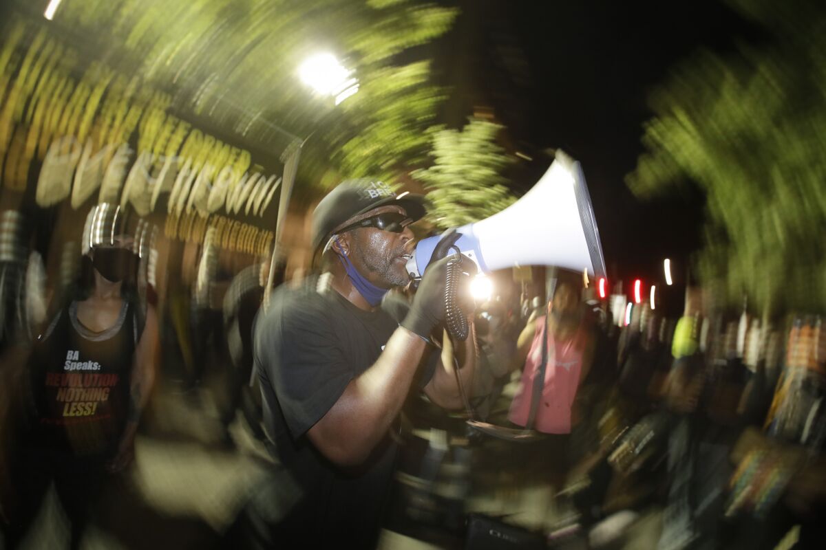A speaker addresses the crowd during a Black Lives Matter protest at the Mark O. Hatfield United States Courthouse Thursday, July 30, 2020, in Portland, Ore. After days of clashes with federal police, the crowd outside of the federal courthouse remained peaceful Thursday night. (AP Photo/Marcio Jose Sanchez)