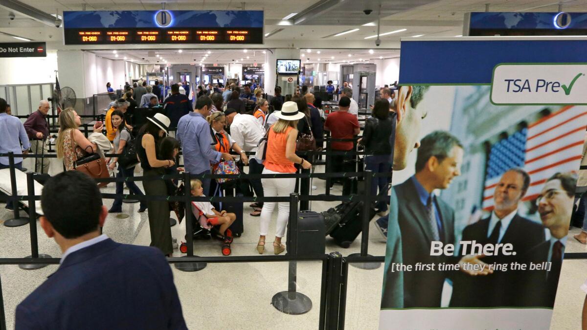 Travelers stand in line as they prepare to pass through a Transportation Security Administration checkpoint at Miami International Airport on May 26. Memorial Day weekend, the unofficial start of summer vacations for many and a busy travel period, serves as a crucial test for the TSA.