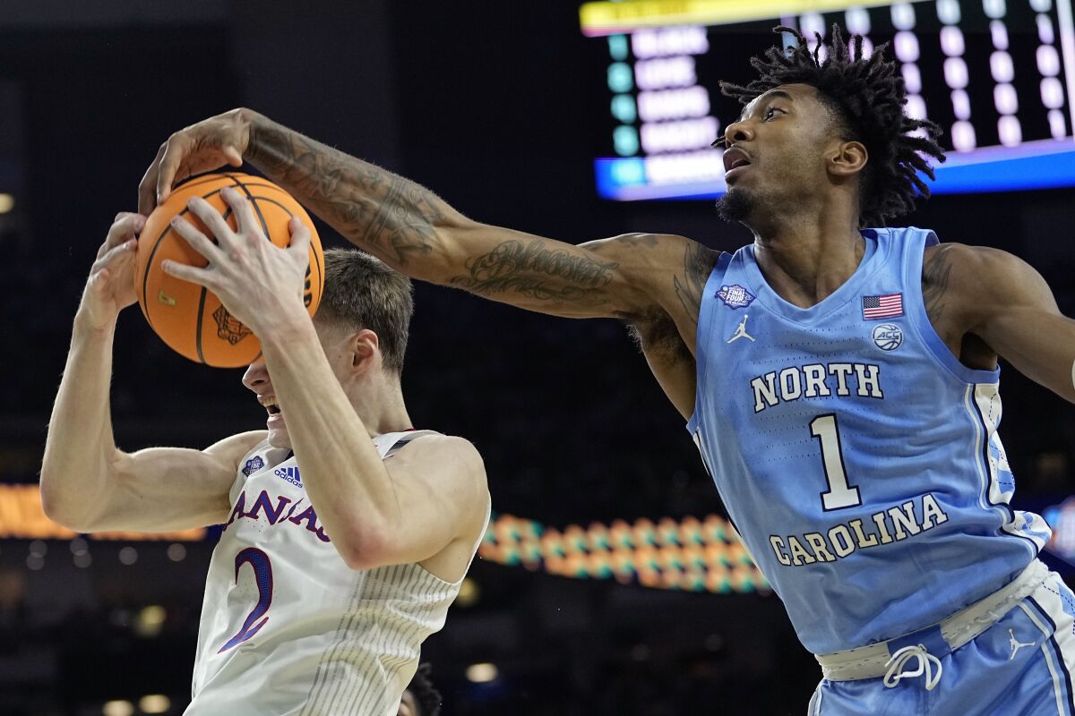 North Carolina guard Leaky Black, right, blocks a shot by Kansas guard Christian Braun during the first half of a college basketball game in the finals of the Men's Final Four NCAA tournament, Monday, April 4, 2022, in New Orleans. (AP Photo/David J. Phillip)