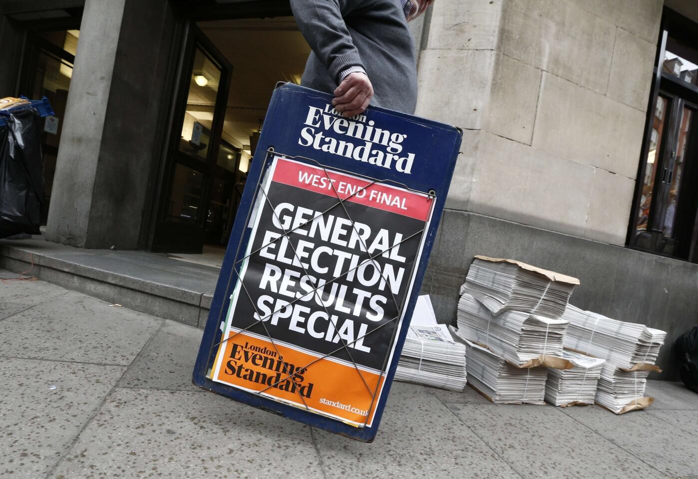 A newspaper vendor sets out his stall in central London, a day after the British general election. British Prime Minister David Cameron's Conservative party on Friday won a majority in the House of Commons in the general election, results showed.