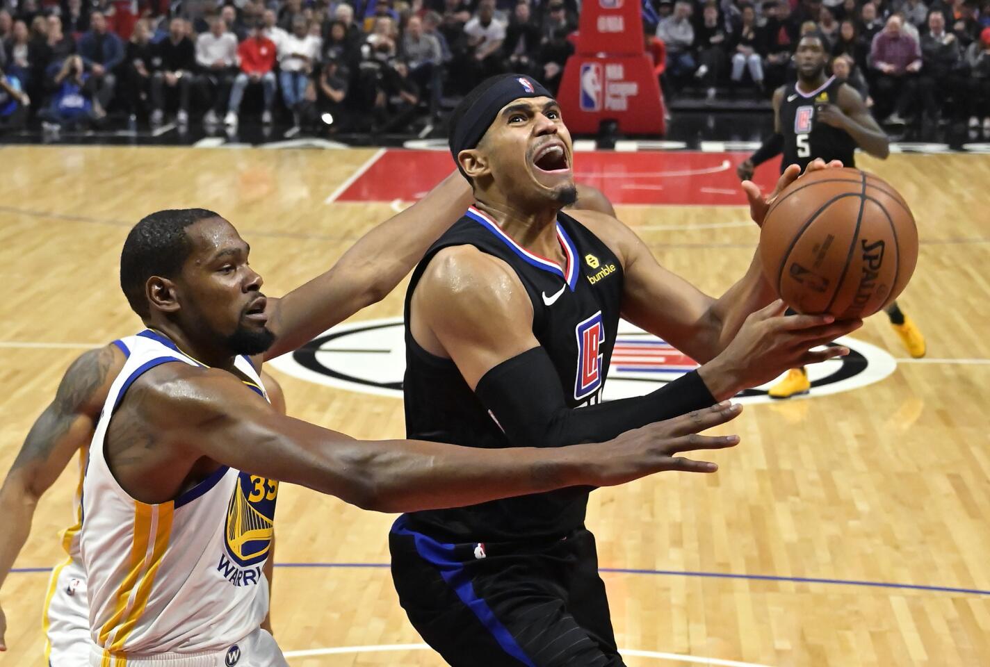 Los Angeles Clippers forward Tobias Harris, right, shoots as Golden State Warriors forward Kevin Durant defends during the second half of an NBA basketball game Friday, Jan. 18, 2019, in Los Angeles. The Warriors won 112-94. (AP Photo/Mark J. Terrill)