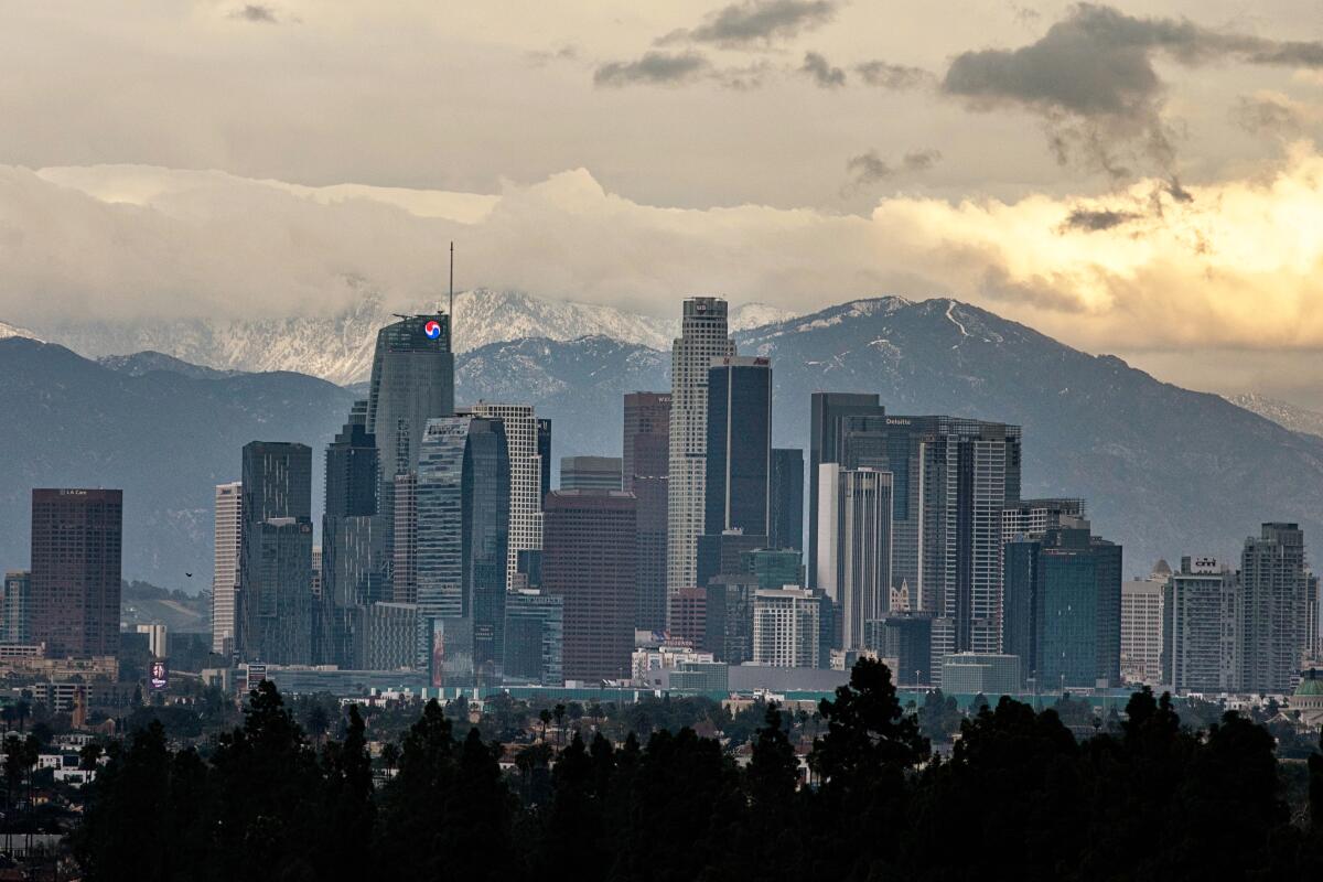 The downtown Los Angeles skyline with snow-capped mountains in the background.