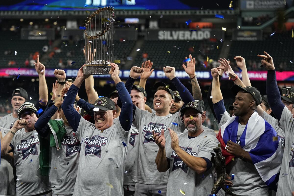 Atlanta manager Brian Snitker holds up the trophy after winning the World Series.