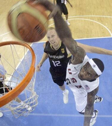 USA's LeBron James and Cleveland Cavalier star dunks as Gemany and Los Angeles Clipper center Chris Kaman looks on.