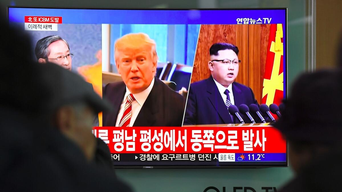 At a railway station in Seoul on Nov. 29, people watch the news. North Korean leader Kim Jong Un is at right on the screen.