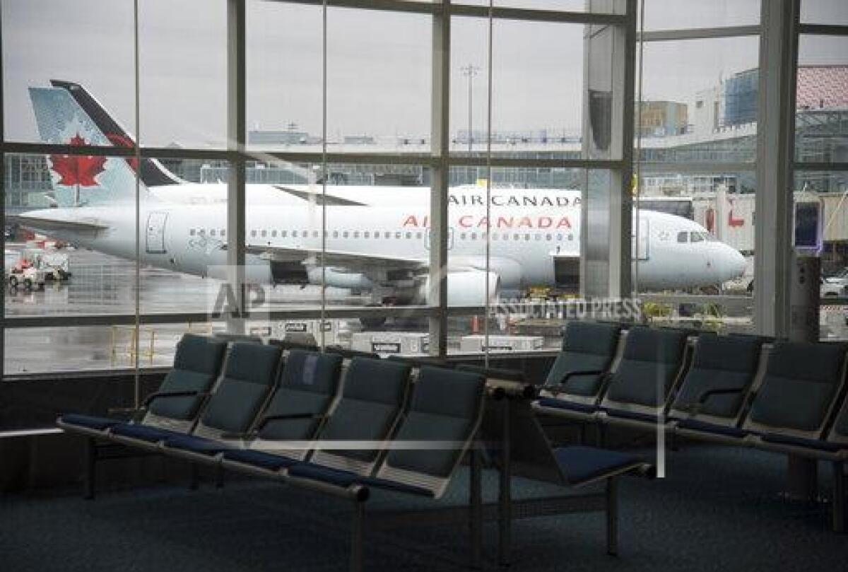 A plane is seen through the window on the tarmac of Vancouver International Airport.