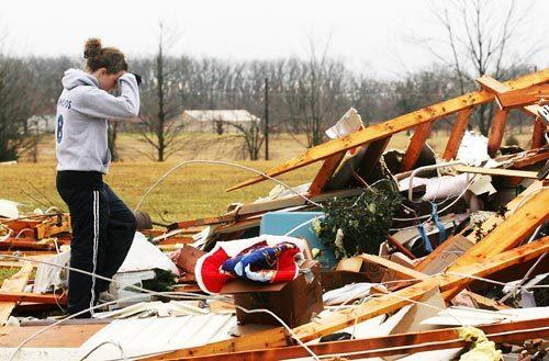 Melina Edmonds pauses while going through the wreckage of her grandmother's home near Strafford, Mo.