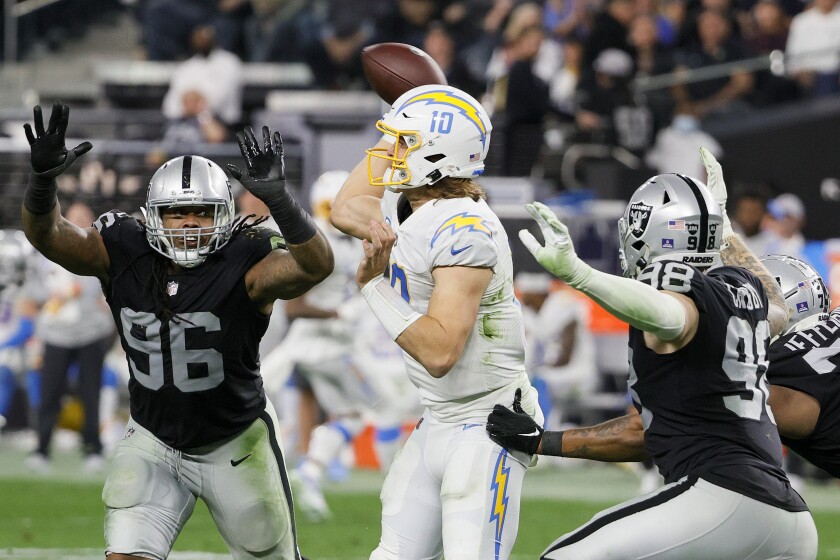 Justin Herbert throws in the fourth quarter of his team's 35-32, overtime loss to the Raiders on Sunday in Las Vegas.