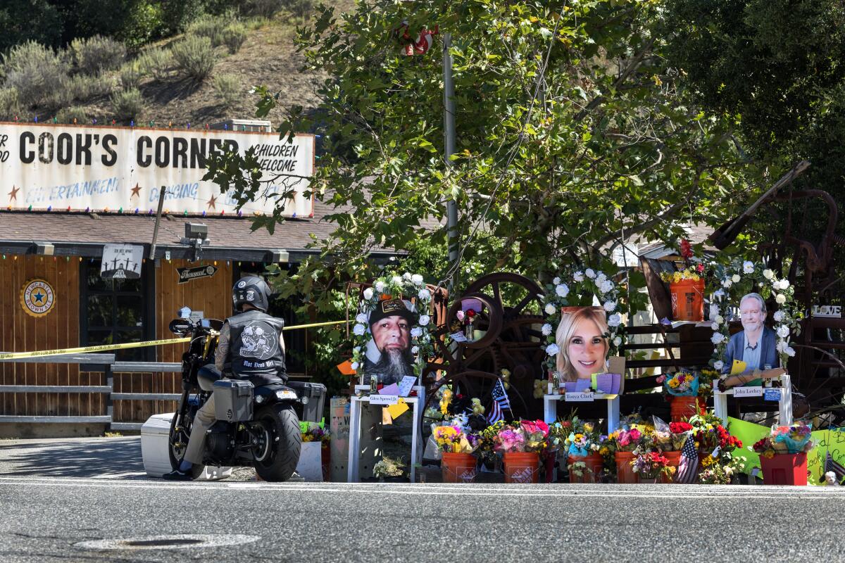 A motorcyclist pays his respects at a memorial to the mass shooting victims at Cook's Corner in Trabuco Canyon in August.