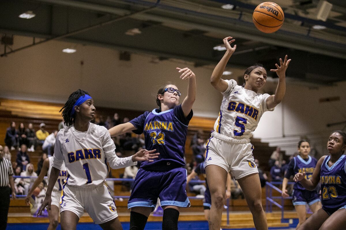 Marina's Rhianna Alaniz goes up for a rebound against Gahr's Jody Colbert, left, and Kameryn Mitchell during Saturday's game.