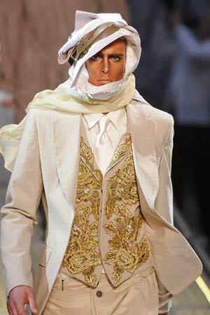 John Galliano channels "Lawrence of Arabia," with a sun-bleached blazer and trousers with embroidered vest and a head wrap.