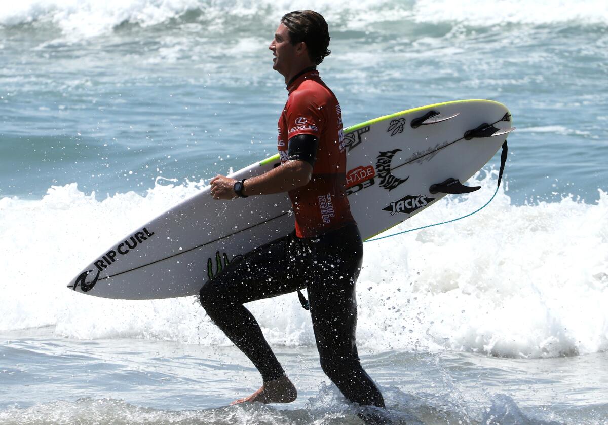 Crosby Colapinto of San Clemente runs to shore after his heat during the U.S. Open of Surfing.