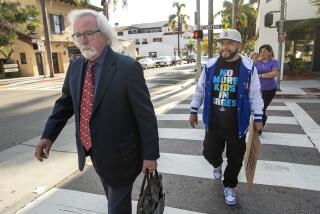 SANTA BARBARA, CA-NOVEMBER 30, 2023:Activist Edin Alex Enamorado, right, pursues Attorney Michael Barmasse, after the arraignment for his client Jeanne Umana at Santa Barbara Superior Court that was continued until January 3, 2024. Umana was caught on two separate videos using racist language to Latino men. As Enamorado followed Barmasse, he yelled out to him, "Are you aware that you're defending a racist bigot? She should be charged with a hate crime." (Mel Melcon / Los Angeles Times)
