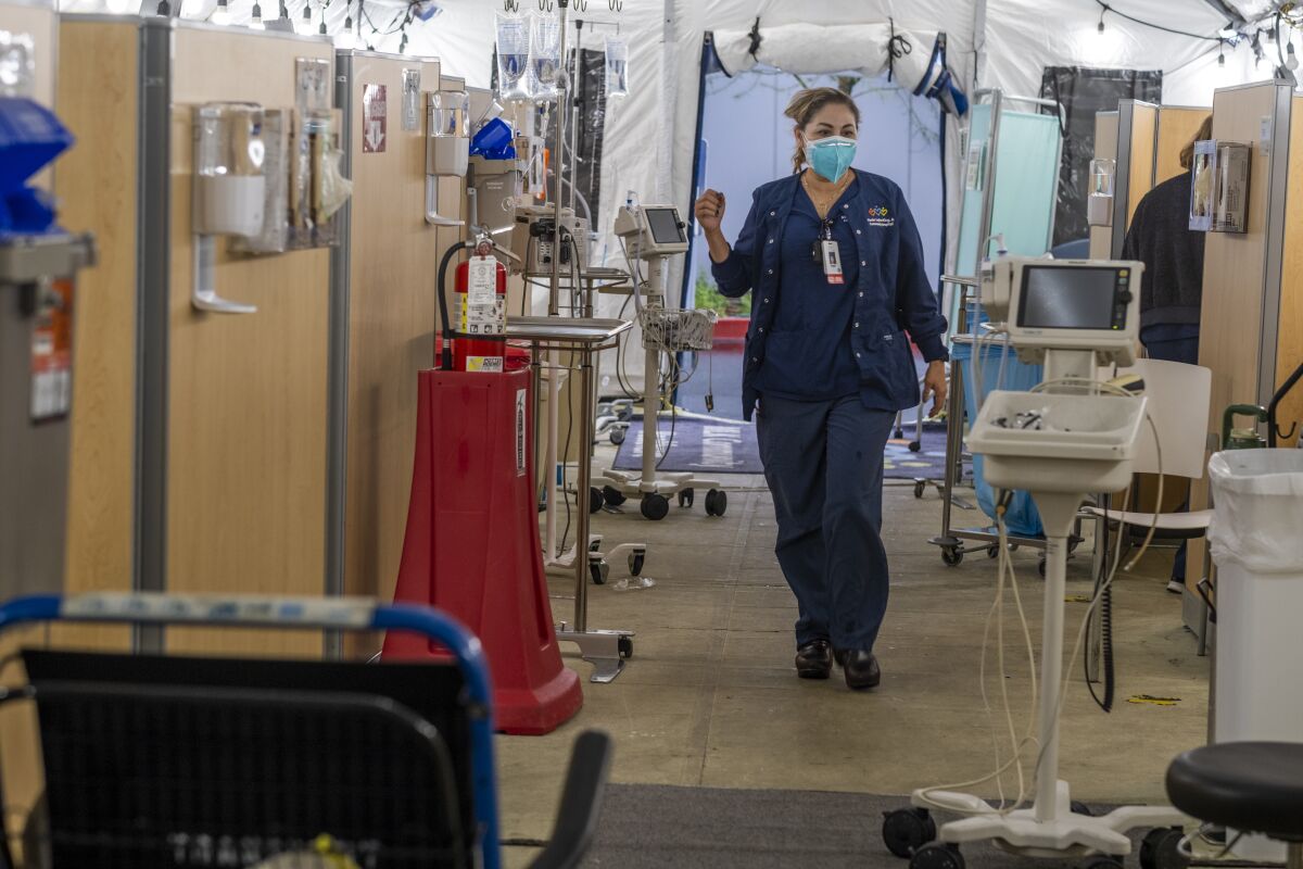 A nurse walks inside a hospital respiratory tent.