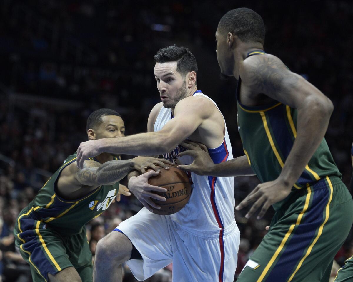 Clippers guard J.J. Redick tries to split the defense of Jazz guard Trey Burke, left, and forward Derrick Favors in the first half Monday night.