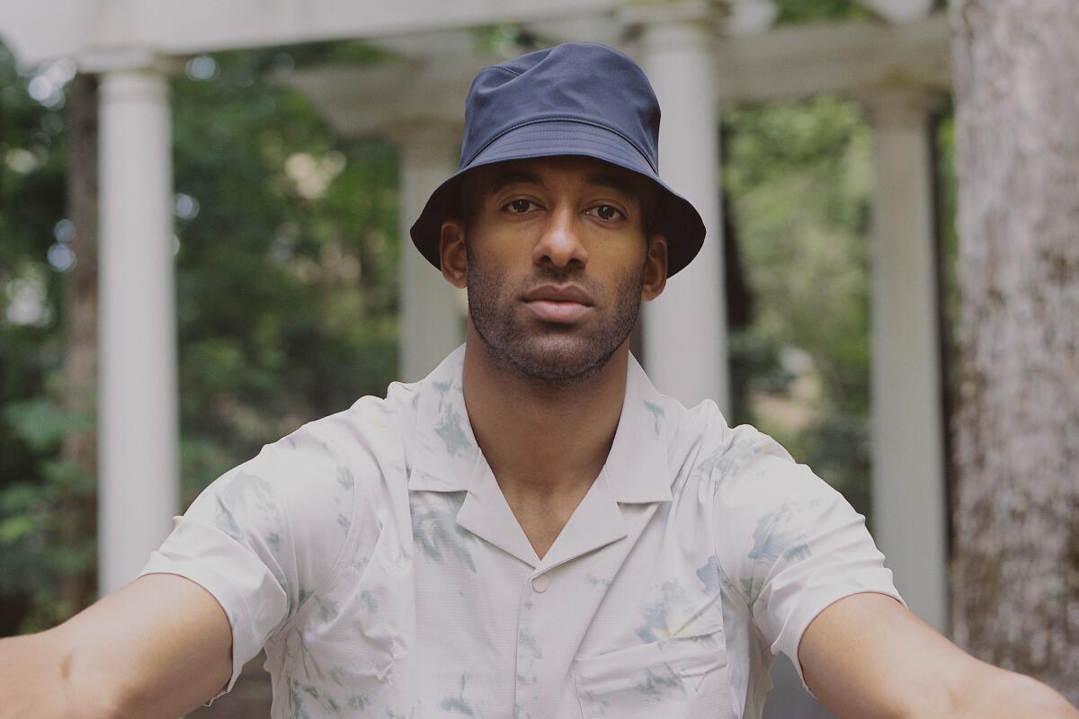 A man in a blue bucket hat and short-sleeve button-down shirt
