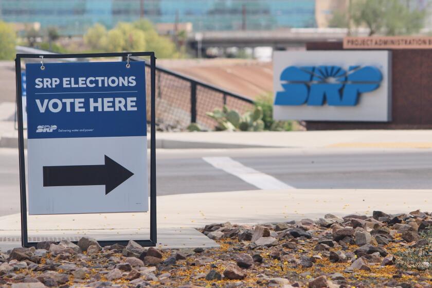 A sign directing voters sits outside the headquarters of Salt River Project on Monday, March 30, 2026, in Tempe, Ariz. (AP Photo/Jonathan J. Cooper)