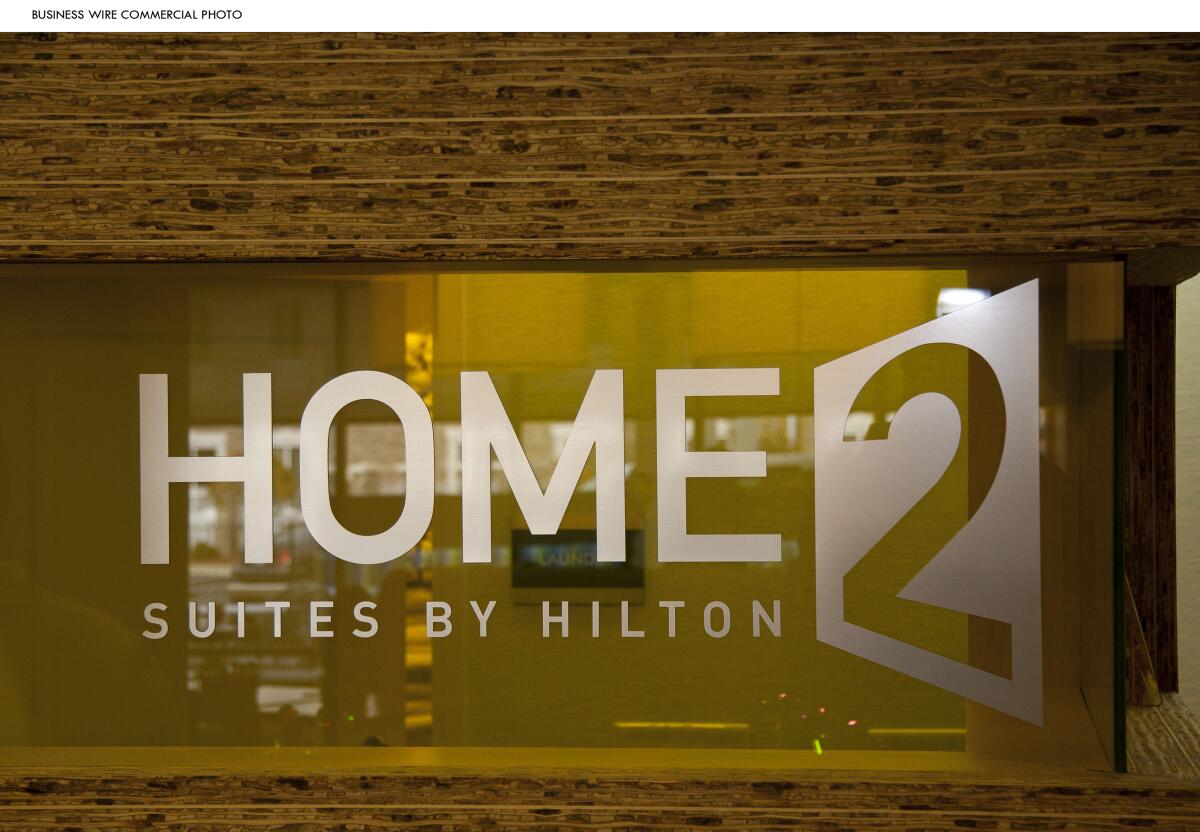 The logo of Home2 Suites by Hilton is etched on a window