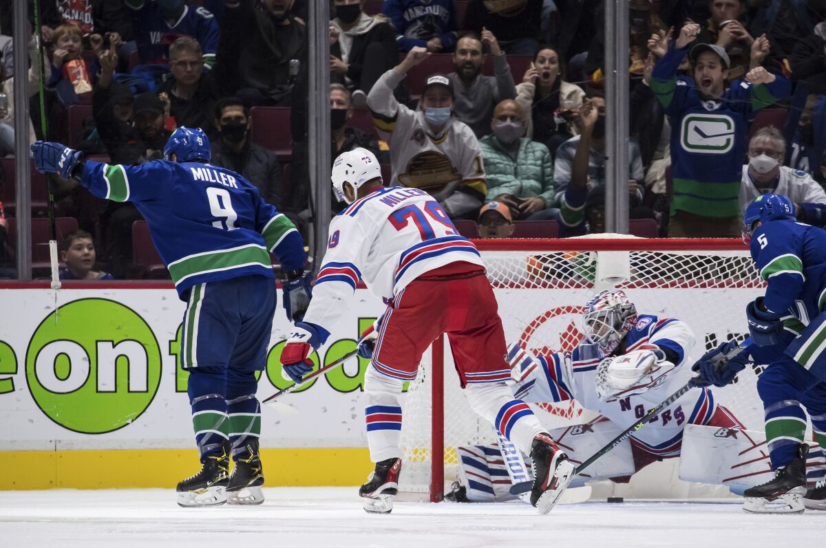 Vancouver Canucks' J.T. Miller (9) celebrates his goal against New York Rangers goalie Igor Shesterkin as K'Andre Miller (79) watches during the third period of an NHL hockey game Tuesday, Nov. 2, 2021, in Vancouver, British Columbia. (Darryl Dyck/The Canadian Press via AP)