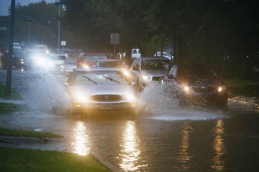 Vehicles splash through heavy water filling Chimney Rock, south of Brays Bayou in Houston, Tuesday, Sept. 17, 2019. Officials in the Houston area were preparing high-water vehicles and staging rescue boats Tuesday as Tropical Storm Imelda moved in from the Gulf of Mexico, threatening to dump up to 18 inches of rain in parts of Southeast Texas and southwestern Louisiana over the next few days. (Mark Mulligan/Houston Chronicle via AP)