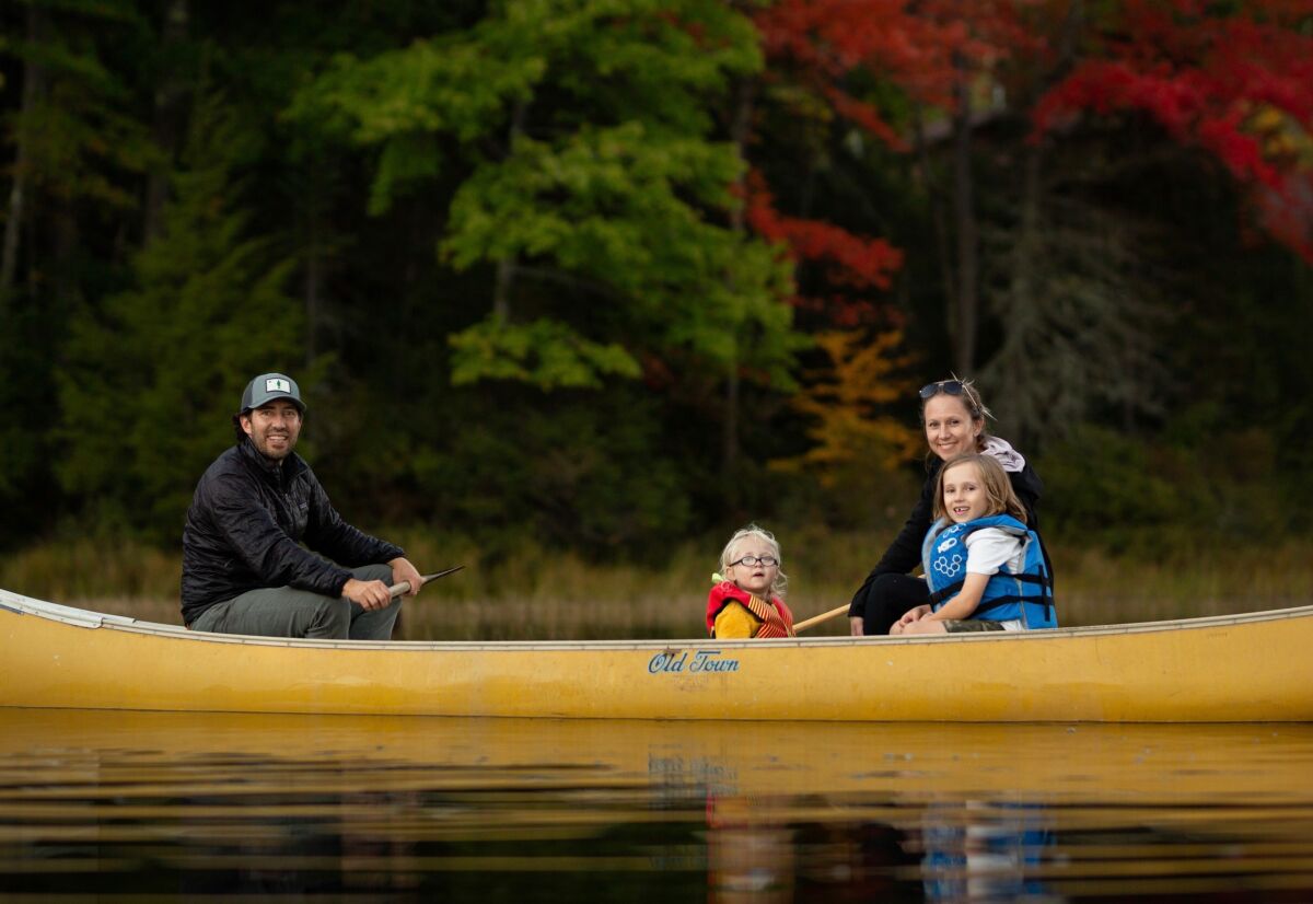 A man, woman and two children in a canoe