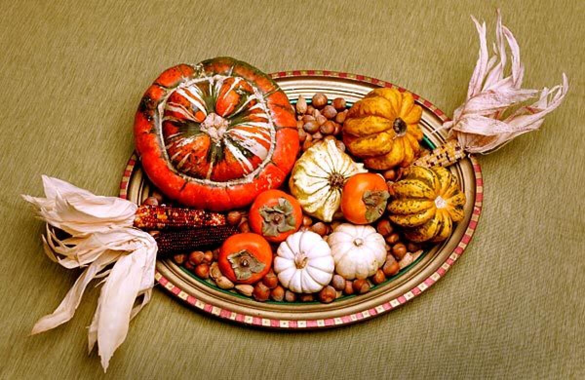 A hand-painted picture frame filled with fruits, vegetables, nuts and dried Indian corn offers a fun twist on the traditional cornucopia.