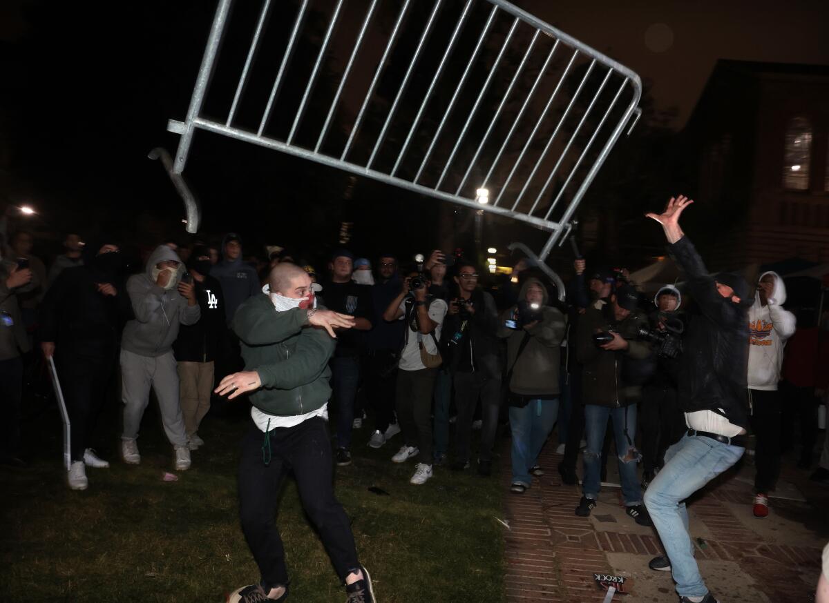 Protesters face off as a recently hurled metal barrier flies through the night air.