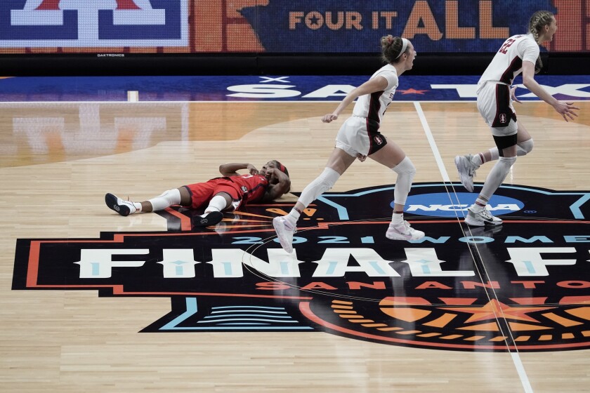 Arizona guard Aari McDonald, left, lies on the court after missing a shot at the end of the championship game against Stanford in the women's Final Four NCAA college basketball tournament, Sunday, April 4, 2021, at the Alamodome in San Antonio. Stanford won 54-53. (AP Photo/Morry Gash)