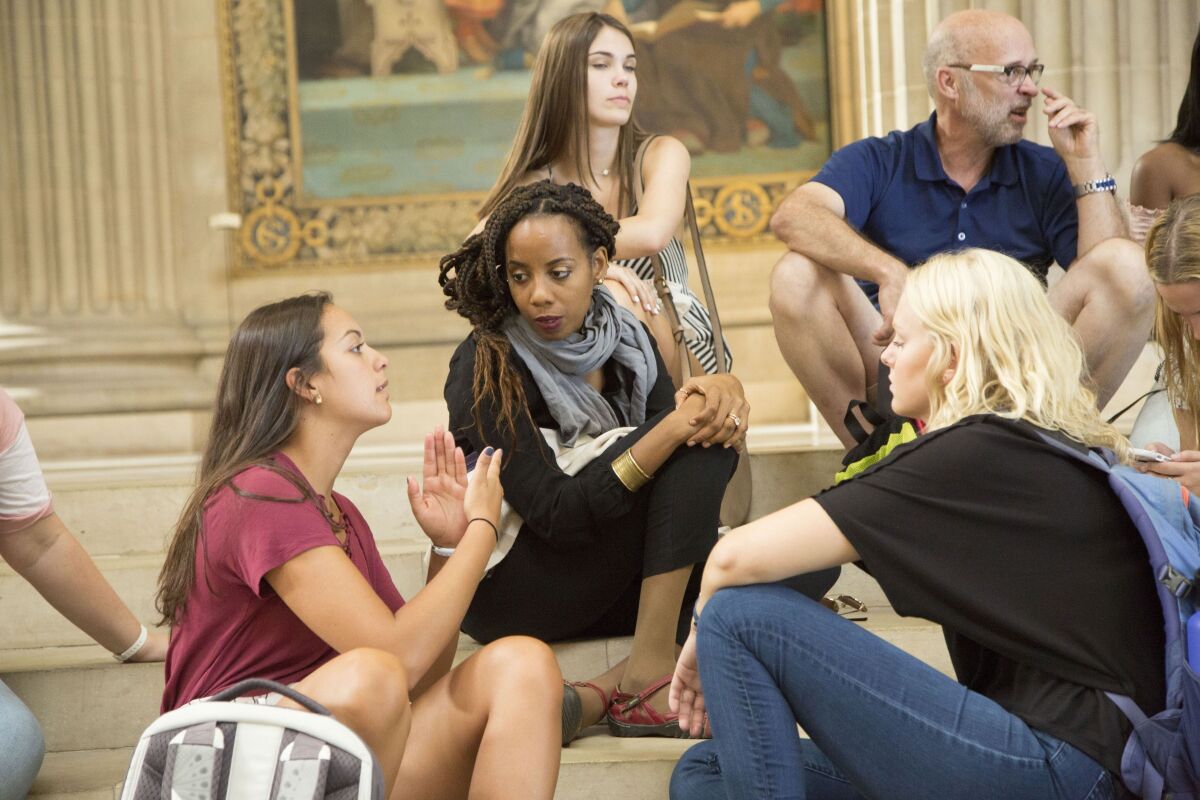 In this photo provided by Centenary College of Louisiana, associate professor Andia Augustin-Billy listens to a student inside the Pantheon in Paris on Aug. 11, 2018, while teaching as part of Centenary College's Centenary in Paris program for first-year students. At 196 years Louisiana's oldest college, Centenary plans a gathering Thursday, Nov. 4, 2021, to honor Augustin-Billy as the first Black person to gain tenure at the school. (Sherry Heflin/Centenary College of Louisiana via AP)