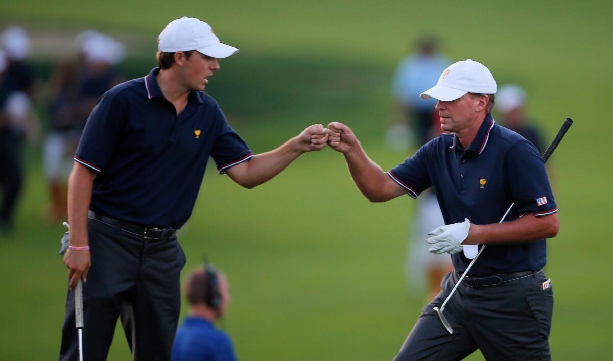 Jordan Spieth, left, and Steve Stricker celebrate on the 18th hole at the Presidents Cup on Thursday.