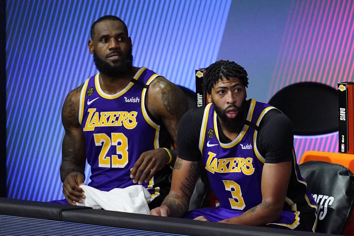 LeBron James and Anthony Davis watch from the bench in the second half of the Lakers' Game 1 loss to the Rockets on Friday.