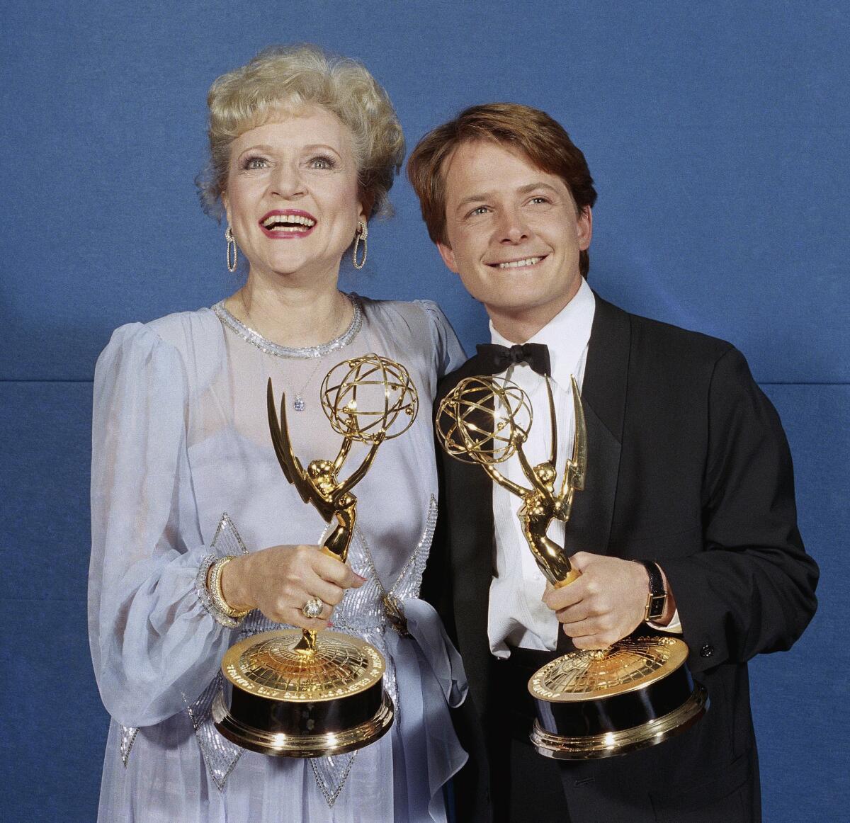 Michael J. Fox and Betty White pose together in 1986, each clutching an Emmy.