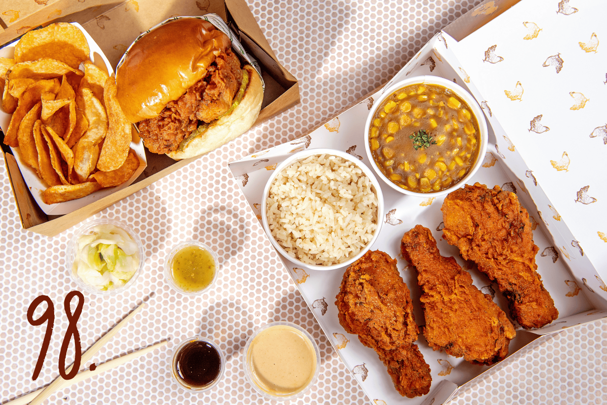 #98: Chicken sandwich, and box with drumsticks, sides of curried corn and rice