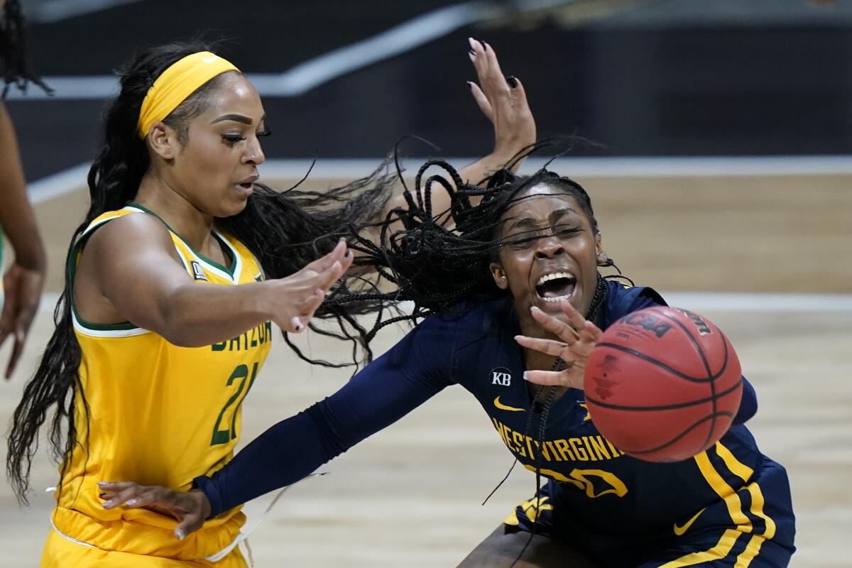 West Virginia's Jayla Hemingway, right, passes the ball under pressure from Baylor's DiJonai Carrington during the first half of an NCAA college basketball game in the final round of the Big 12 Conference tournament in Kansas City, Mo, Sunday, March 14, 2021. (AP Photo/Charlie Riedel)