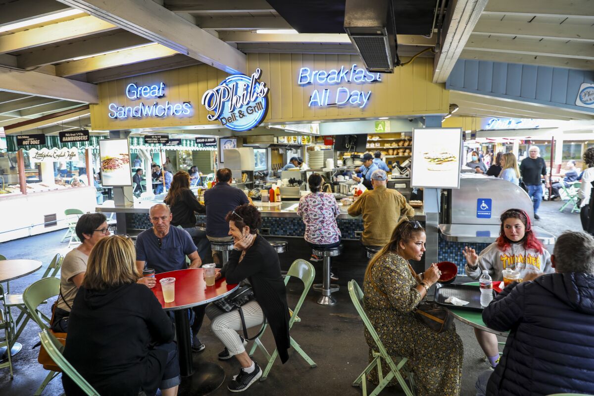People eating at tables under a beamed roof at Phil's Deli and Grill