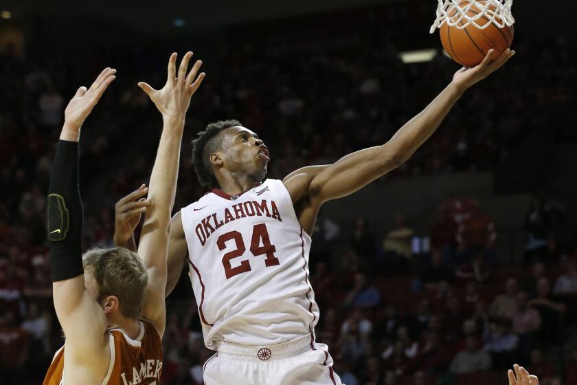 Oklahoma guard Buddy Hield (24) goes around Texas forward Connor Lammert for a layup in the second half.