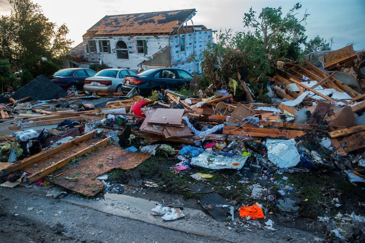 Debris surrounds vehicles after a severe storm passed through Coal City, Ill., on Monday night. Coal City Mayor Terry Halliday said a suspected tornado swept into town, first striking the high school before moving on to damage homes and a fire station.