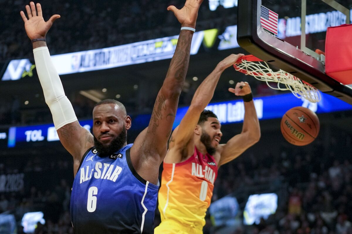 Boston's Jayson Tatum dunks behind LeBron James during the first half of the NBA All-Star Game.