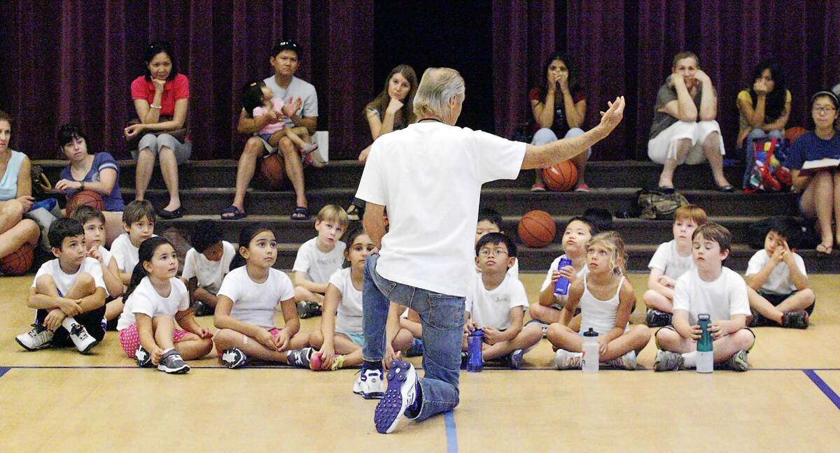 On one knee, Tony Passarella asks the campers what they learned at the ninth annual Kid's Summer Basketball, Training and Fitness Camp at Pacific Park Community Center.