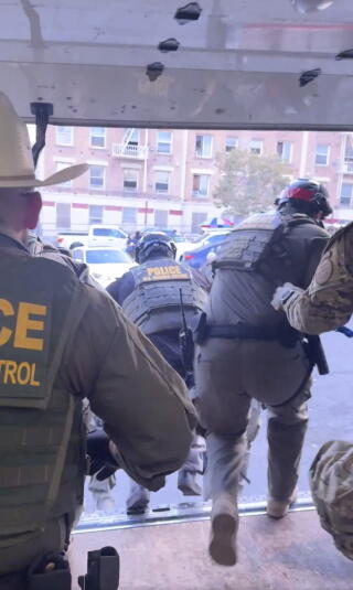 This image taken from video shows U.S. Border Patrol agents jumping out of a Penske box truck.