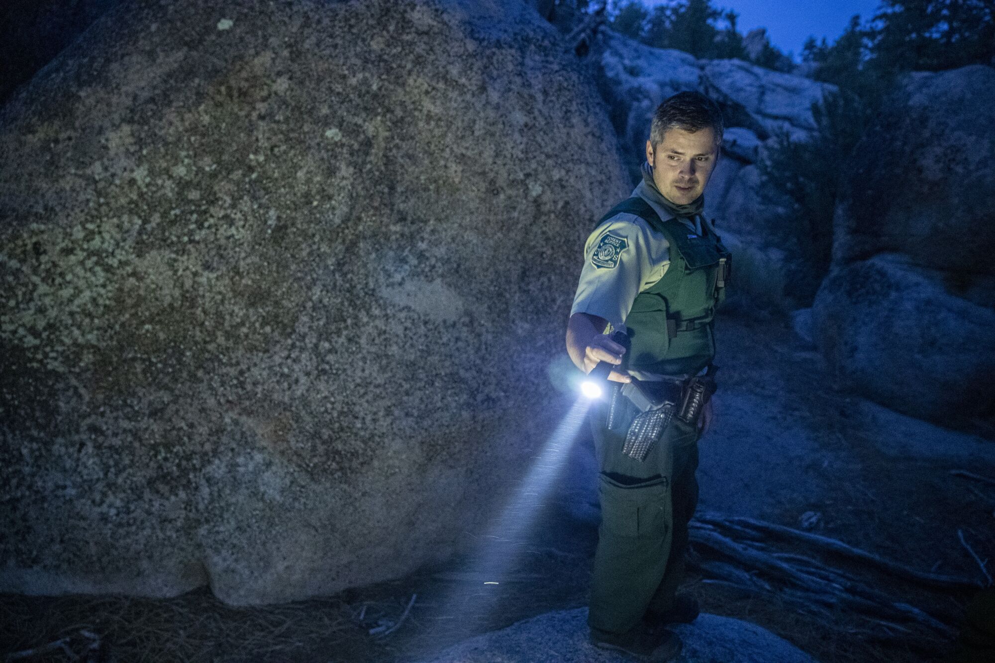  Forest service law enforcement officer Tyler Smith looks for evidence of illegal camping while on patrol 