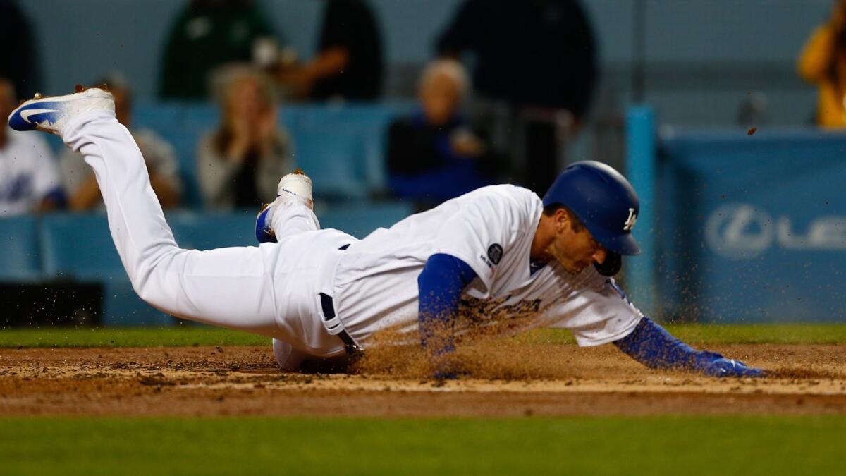 Dodgers infielder David Freese safely slides into home plate, scoring a run against the San Francisco Giants during a game at Dodger Stadium on Wednesday.